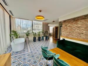 第比利斯Abanotubani Boutique hotel的客厅配有绿色沙发和一些植物
