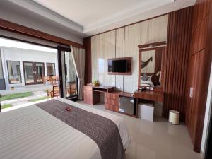 ToyapakehGrand Yuna Hotel Nusa Penida的一间卧室配有一张大床和电视