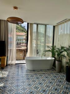 第比利斯Abanotubani Boutique hotel的带浴缸的浴室和大窗户