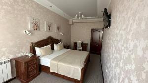彼得罗巴甫洛夫斯克Altyn Adam Hotel的一间卧室设有一张床和一面墙