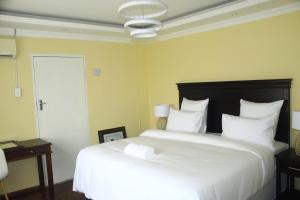 彼得马里茨堡Suprime Hotels and Conference的卧室配有白色大床和白色枕头