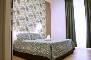 罗马乔欧酒店的一间卧室配有一张带花卉壁纸的床