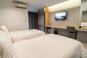 Ban Nong WaengGoodday Hotel的酒店客房配有两张床和一张书桌