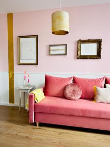 比勒费尔德Gallery Apartment Bielefeld的客房内的粉红色沙发上配有枕头