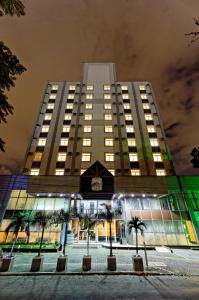 瓜鲁柳斯瓜鲁柳斯黑貂酒店的一座高大的建筑,前面有棕榈树