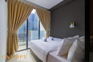 吉隆坡The Colony & The Luxe, Kuala Lumpur by Canopy Lives的一间卧室设有一张床和一个大窗户