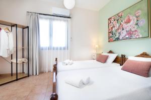 阿斯特里昂Villa Marilia的一间卧室设有两张床,墙上挂着一幅画