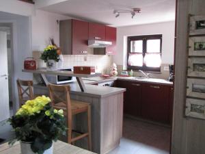 希伯维列Le Bretzel的一间厨房,配有红色橱柜和台面