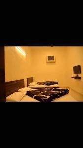 阿姆利则Hotel Bindra Paradise 800 Meter From Golden Temple的一间卧室设有两张床,墙上配有电视。
