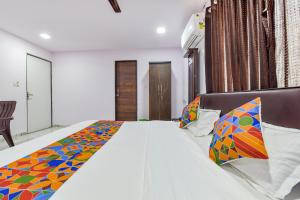 艾哈迈达巴德FabHotel Vishwa Palace的一间卧室配有一张大床和色彩缤纷的毯子