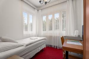 鲁哈科维斯Vila Charleston的卧室配有一张床、一张书桌和窗户。