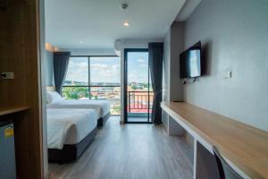 Ban Nong WaengGoodday Hotel的酒店客房设有两张床和一个阳台。