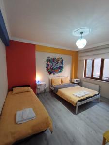 埃斯基谢希尔Deeps Hostel Eskişehir的一间卧室设有两张床,墙上挂着一幅画