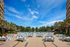 富国Best Western Premier Sonasea Phu Quoc的度假村的宴会区配有白色的桌椅