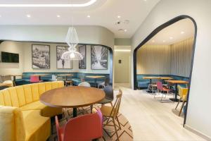阿尔考本达斯Hampton By Hilton Alcobendas Madrid的用餐室配有桌椅和沙发