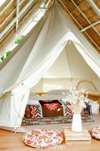 格兰岛Tawaen Caza Sky Camping的白色帐篷,配有板子和桌子上的花瓶