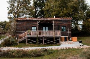 BusserollesLa ferme du pont de Maumy, cabane au bord de l'étang et bain nordique的小木屋设有门廊和甲板