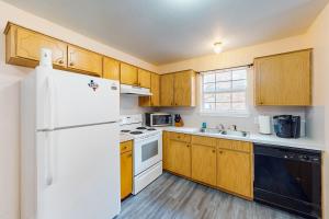 基林Killeen Serene的厨房配有木制橱柜和白色冰箱。