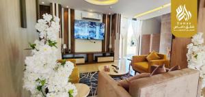 Al Maraghahداماس للأجنحة الفندقية Damas Hotel Suites的带沙发和桌子及鲜花的客厅
