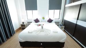 沙湾拿吉Bouasavan Hotel and Garden的一间卧室配有一张白色大床,床上有鲜花