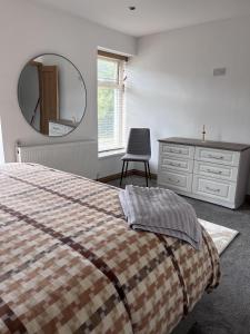 埃布韦尔Modern Newly Renovated 3 Story House in Ebbw Vale的一间卧室配有一张床、梳妆台和镜子
