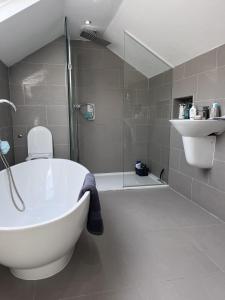 埃布韦尔Modern Newly Renovated 3 Story House in Ebbw Vale的带浴缸、卫生间和淋浴的浴室。