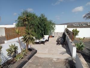 圣巴尔托洛梅Quintero Suites的一个带长椅和棕榈树的庭院和围栏