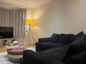 伍德福德格林Forest Edge的带沙发和电视的客厅