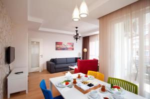 安塔利亚客房公寓式酒店的客厅配有白色的桌子和椅子