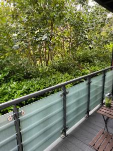 邓斯特布尔Grove flat - two bedroom flat in central Dunstable的木甲板,配有长凳和灌木丛