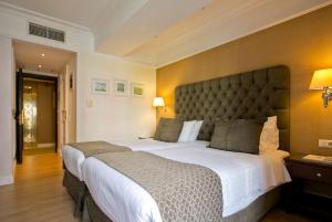 雅典赫拉酒店的一间卧室配有一张大床和大床头板