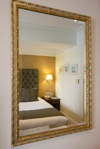 雅典赫拉酒店的墙上的镜子,房间里的床