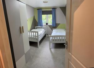 邓斯特布尔Grove flat - two bedroom flat in central Dunstable的小房间设有两张床和窗户