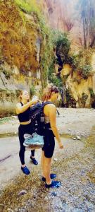 达纳Adventure camping - Organized Trekking from Dana to Petra的两个女人站在一幅山画旁边
