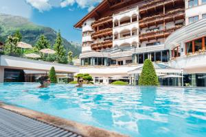 伊施格尔Trofana Royal 5-Sterne Superior Resort的两人在酒店的游泳池