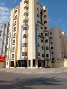 杰赫拉Days Inn By Dahlia -Hotel Apartment - Al Jahra的街道前方的大型公寓楼