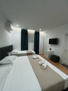 地拉那Clinton Tirana Inn的一间卧室配有两张大床和毛巾