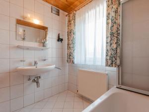 克尼格利斯滕Apartment Voithofer-1 by Interhome的一间带水槽和浴缸的浴室以及窗户。