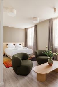 里摩日Gogaille - Gambetta - accès autonome的一间卧室配有一张床、两把椅子和一张桌子