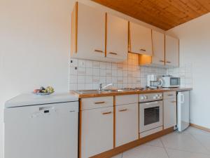 克尼格利斯滕Apartment Voithofer-4 by Interhome的厨房配有白色橱柜和水槽