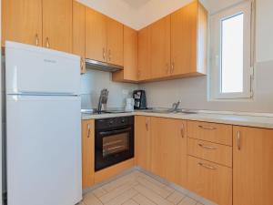 宁Apartment Mlasina-3 by Interhome的厨房配有木制橱柜和白色冰箱。