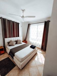 马林迪Mawingu Loft的一间卧室设有一张床和一个大窗户