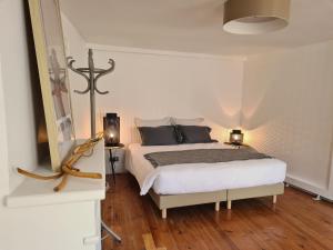 塞纳河畔诺让Le Relais de l'endormie的一间白色卧室,配有一张床和两盏灯
