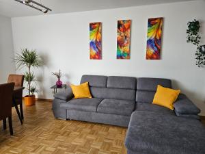 EssenFelde SLP 3- Zimmer Ferienwohnung in Essen- Steele的客厅配有沙发,墙上有三幅画作