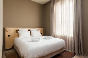 里摩日La Loge Gogaille - Gambetta - accès autonome的卧室设有一张白色大床和一扇窗户。