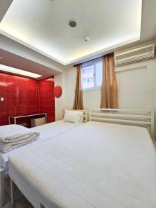 首尔Travelers A Korea Hostel的红色瓷砖的客房内的两张床