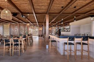 阿默达拉-伊拉克利翁Sentido Amounda Bay的餐厅设有木制天花板和桌椅