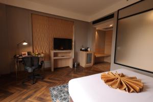 阿加尔塔拉Hotel Polo Towers Agartala的酒店客房,配有床和电视