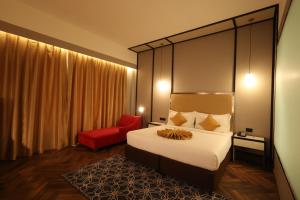 阿加尔塔拉Hotel Polo Towers Agartala的酒店客房,配有一张床和一张红色椅子