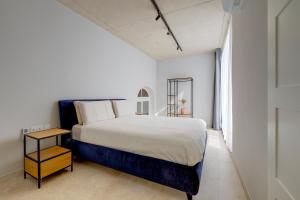 斯利马Seafront Traditional Maltese Townhouse Balluta Bay的白色的卧室设有一张大床和一个窗户